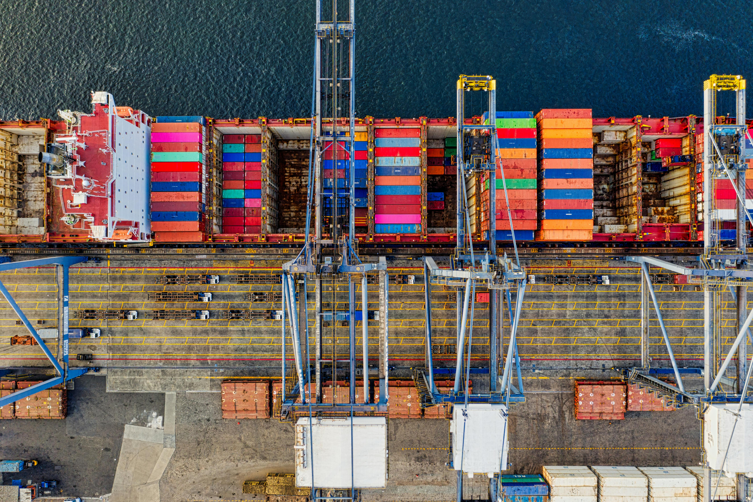 Massvis med containers på ett fartyg i en hamn.