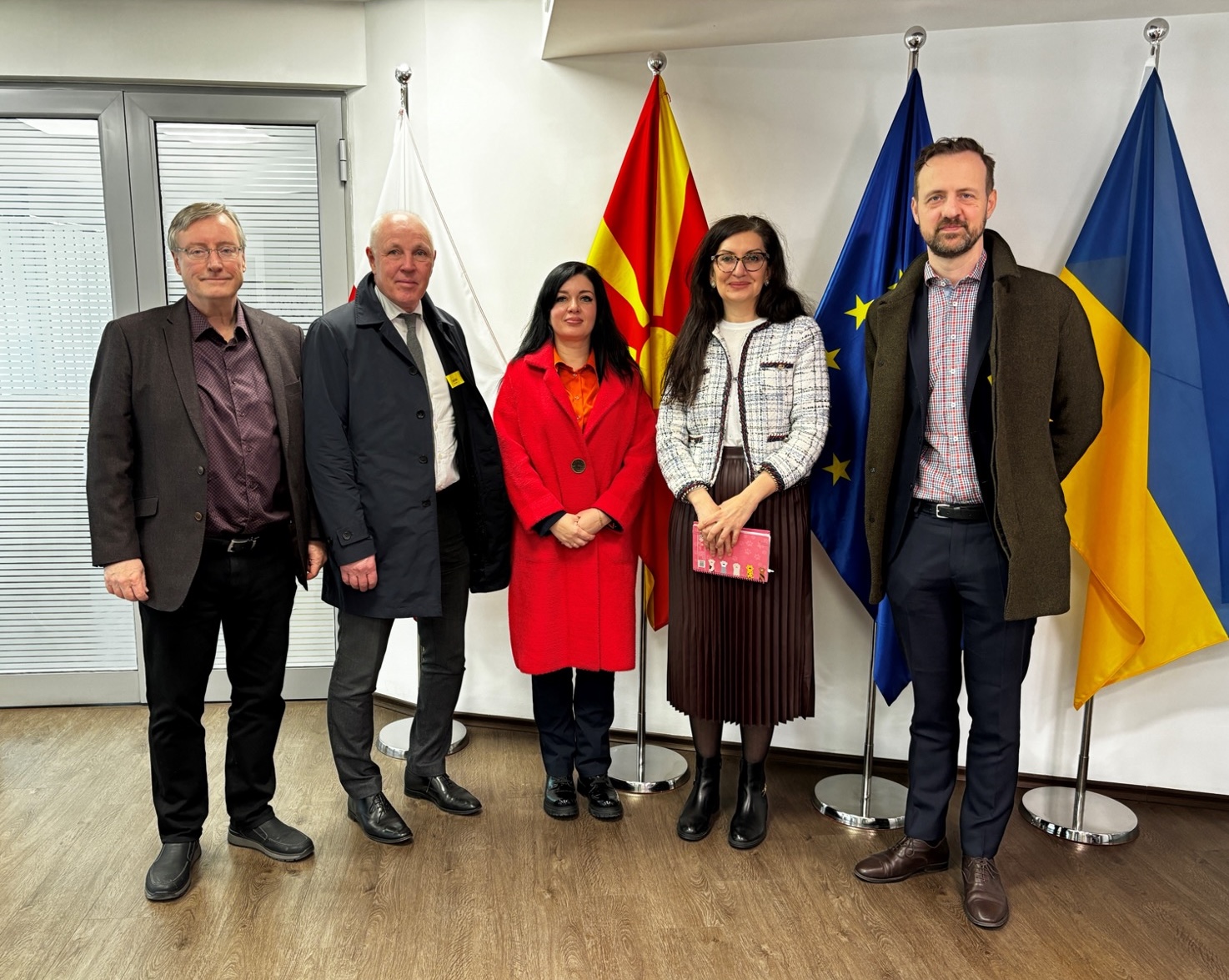 Fem personer som står på rad framför tre flaggor i ett konferensrum. Medverkande i bild: Mikael Joabson, Peter Kronvall och Tetiana Melnychenko, Swedac, Georgieva Elisabeth, Delegation of the European Union to the Republic of North Macedonia och Fredrik Lindahl, Swedac.